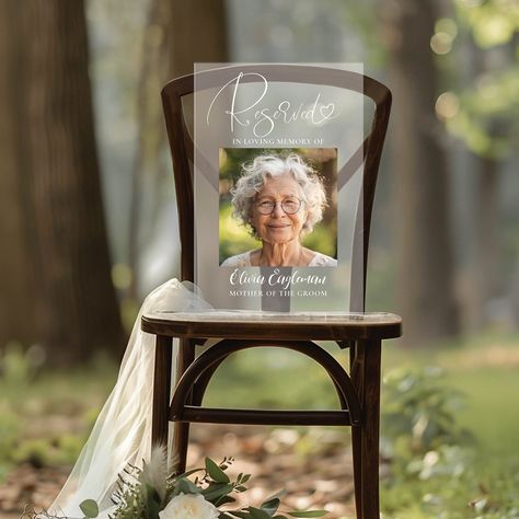 The "Reserved" Memorial Photo Sign is an ideal way to pay tribute to your loved ones on your wedding day. This customizable frosted acrylic plaque acts as both a heartfelt memorial and an elegant decor element. Perfect as a sympathy gift or wedding remembrance, it beautifully honors those who will always hold a special place in your heart. Remembering People At Wedding, Memorial Pieces For Wedding, At Last Wedding Theme, Wedding For Passed Loved Ones, Memorial Wall For Wedding, Wedding Memorial Seat Ideas, Reserved In Memory Wedding Seat, In Loving Memory Ideas For Wedding, Wedding Reception Memory Table