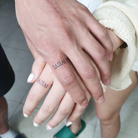 Wedding Ring Tattoos: Roman Numeral Ring Tattoo. The wedding date tattooed in a Roman numeral style. Click through for 30 wedding ring tattoo ideas. #weddingringtattoos #ringtattoos #weddingideas IG: @zerotattoo_fashion Roman Numeral Wedding Band Tattoo, Finger Tattoo Small, Hand Tattoo Minimalist, Tatoo Ring, Ring Finger Tattoo Couple, Wedding Ring Finger Tattoos, Wedding Date Tattoos, Wedding Ring Tattoos, Marriage Tattoos