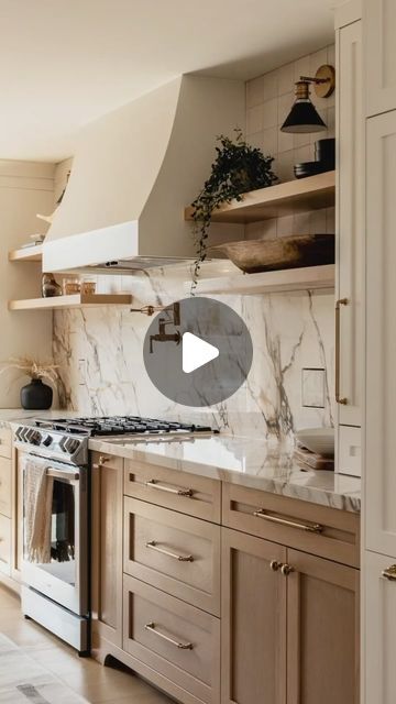 Interior Alchemy - Interior Design Inspiration on Instagram: "This stunning kitchen effortlessly blends elegance and functionality. The marble backsplash and countertops add a touch of luxury, while the warm wood cabinetry brings a cozy feel. The floating shelves and sleek brass hardware offer modern sophistication. A pot filler above the stove is both practical and stylish. For a similar look, consider incorporating open shelving to display your favorite decor and opt for a neutral color palette to keep the space bright and inviting ✨🤍  Save for later!  #KitchenDesign #InteriorInspo #MarbleBacksplash #ModernKitchen #WarmInteriors #HomeDecor #DesignIdeas #LuxuryLiving #KitchenGoals #interioralchemyhq  @natcaronphoto" Marble Open Shelves Kitchen, Vent Hood With Open Shelves, Open Shelves By Stove, Open Shelves Around Kitchen Window, Kitchen Backsplash Above Stove, Stove Area Ideas Kitchen, Hood With Open Shelving, Hood With Floating Shelves, Range Hood With Open Shelving