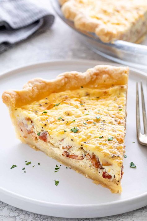 This quiche lorraine recipe has a delicious creamy custard filled with cheese, and salty bits of bacon served in a homemade flaky pie crust. #quiche #quichelorraine Quiche Lorraine Recipe, Ham And Cheese Quiche, Honey Ham, Baked Pie Crust, Cheese Quiche, Flaky Pie Crust, Custard Filling, Homemade Pie Crusts, Quiche Lorraine