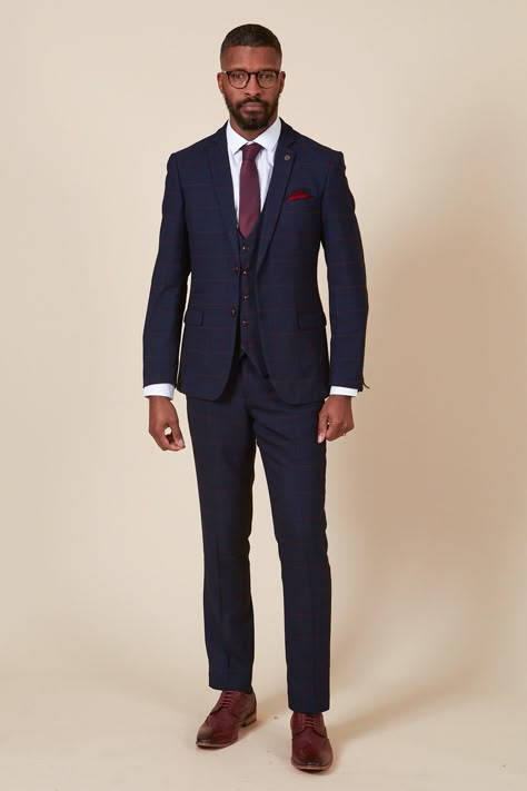 Ticking all the boxes, this men's navy three piece is simple and sophisticated in its design. Cut to a slim tailored fit, it features a deep burgundy check laden on a subtle navy Prince of Wales check. Added elastane ensures flexible easy wear that will keep you comfy from the aisle to the dancefloor. Perfect for tying in with a rich burgundy wedding theme, this suit will work for all the groomsmen. Try switching up the waistcoat for a varied look and to match the bridesmaids. Also available in Navy Suit Maroon Tie, Navy Suit Burgundy Tie Wedding, Blue Suit Burgundy Tie Wedding, Navy Blue Suit With Burgundy Tie, Men Wedding Suit Ideas, Blue Suit Burgundy Tie, Blue Suit Maroon Tie, Blue And Burgundy Suit, Navy Suit Outfit Men