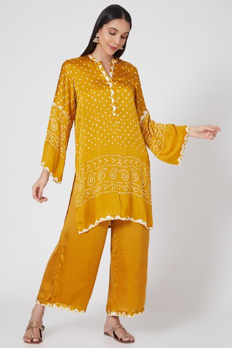 Featuring a yellow short kurta in silk bandhani base with v-neck and a chakri detailing at the back. It is paired with matching pants.  FIT: Fitted at bust and waist. COMPOSITION: Silk bandhani. CARE: Dry clean only. Bandhani Dress Pattern, Stylish Indian Outfits, Diwali Edit, Bandhani Kurta, Trendy Kurtis, Long Kurti Patterns, Co Ords Outfits, Stylish Kurtis Design, Bandhani Dress