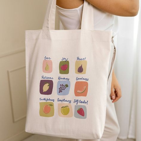 This Fruits of the Spirit canvas tote is perfect for Bible Study or grabbing some fruits and veggies at the Farmers Market! Makes a great gift, too! This 100% cotton bag comes in one size - 15" x 16"- perfect for everyday wear. While the canvas material will show off your designs in great colors, it's durable and will last for years. The bag features 20" handles (made from the same canvas), making it easy to carry even with a week's worth of shopping. .: 100% cotton canvas .: Available in natura Bible Study Tote Bag, Bible Study Bag, Study Bag, Bible Tote Bag, Bible Verse Painting, Christian Accessories, Fruits Of The Spirit, Fruit Bag, Christian Tote Bags