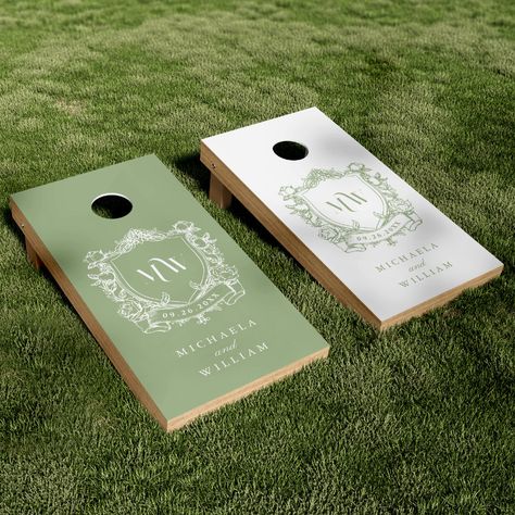 Celebrate love in the great outdoors with this elegant couple's crest cornhole set tailored for your wedding reception. This beautifully designed set offers a touch of nature's serenity mixed with the bespoke charm of personalized detailing, ideal for adding a refined outdoor element to your wedding reception or garden party. The set features two cornhole boards, each boasting a distinguished vintage regency style botanical crest that frames the couple's initials in a delicate modern font. One b Summer Outdoor Wedding Reception, Cornhole For Wedding, Outdoor Games For Wedding Reception, Green Plates Wedding, Custom Wedding Cornhole Boards, Unique Outdoor Wedding Ideas, Cornhole Boards Designs Wedding, Sage Green White And Gold Wedding, Cornhole Board Wedding