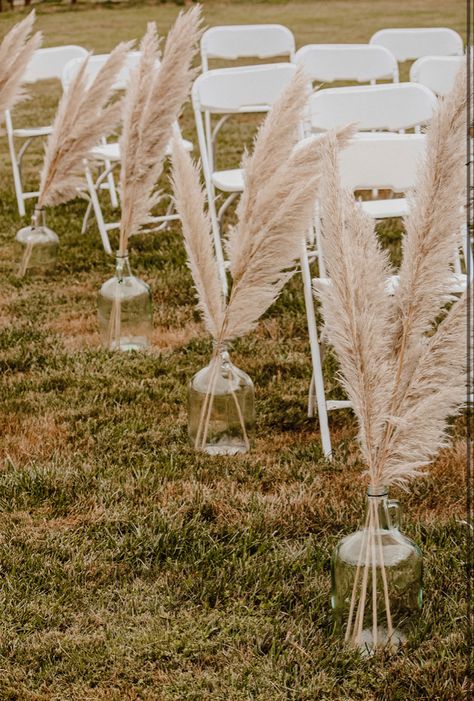 Pampas Grass In Jugs Wedding, Boho Chic Wedding Aisle Decor, Pompous Grass Wedding Decorations, Pampas Grass Ceremony Decor, Simple Western Wedding Table Decor, Small Wedding Ideas Western, Pompis Grass Wedding Decor, Rustic Wedding Decor Aisle, Pampas Grass Isle Wedding Decor