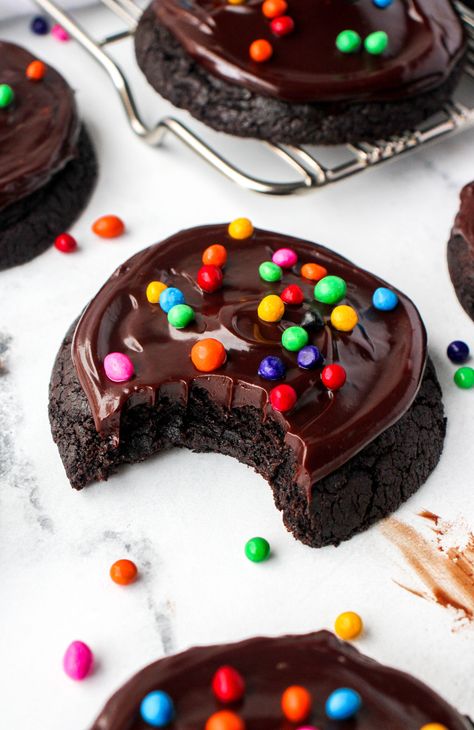 Say hello to this upgraded cookie version of your favorite childhood treat! These Cosmic Brownie Cookies are rich chocolate cookies with a shiny chocolate ganache frosting. They are topped with the traditional cosmic brownie chips, and make for a chocolate lovers heaven! Chocolate Cookies With Ganache, Flavored Brownie Recipes, Super Yummy Desserts, Less Sweet Cookies, Crumbl Cosmic Brownie Cookies, Cosmic Brownie Cookies Recipe, Fudge Fancy Cookies, Cookies Recipes Crumble, Cosmic Brownie Cupcakes