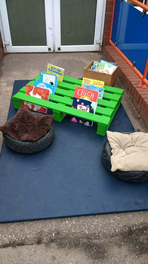 Reading area outdoors with a pallet Eyfs Outdoor Construction Ideas, Outdoor Areas For Preschool, Outdoor Reading Area School, Outdoor Area Ideas Eyfs, Indoor Outdoor Classroom, Outdoor Book Area Eyfs, Outside Classroom Ideas Outdoor Spaces, Outside Areas Eyfs, Classroom Outdoor Area