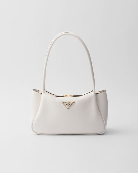 Leather handles Metal hardware Enameled metal triangle logo on the front Zipper closure Nappa lining with three compartments White Summer Bag, White Purse Aesthetic, White Bag Aesthetic, Trendy Designer Bags, White Designer Bag, Pink Prada Bag, Tas Prada, Prada Purse, Prom Bag