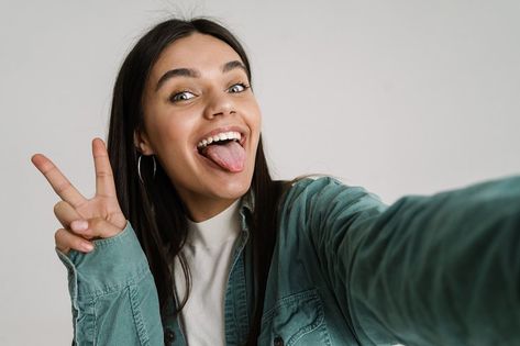 Young woman gesturing peace sign while taking selfie photo isolated over white background Double Peace Sign Pose Reference, Peace Sign Selfie, Peace Selfie, Peace Sign Pose, Taking Selfie, Insta Baddie, Sketchbook Inspo, Pose References, Taking Selfies