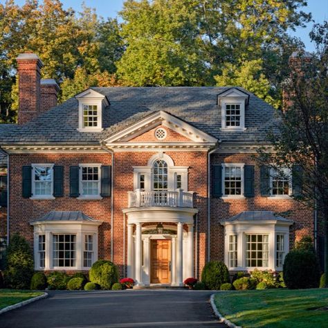 This new 7,000 square foot brick home was built for a growing young family as a long-term family homestead. The Georgian revival style was chosen to help the house fit seamlessly into the neighborhood, a region already marked by its early 20th century Georgian and Tudor Revival homes. #redbrickhouse #slateroof #modillions #dormers #palladianwindow #doriccolumns #windowbay #frontportico #curvedporch #georgianstyle #traditionalarchitecture #classicaldesign #khakumwood #GreenwichCT Georgian Revival Homes, Georgian Style Homes, Dream Things, Georgian Architecture, Brick Exterior House, Georgian Homes, Sims House, Colonial House, Dream House Exterior