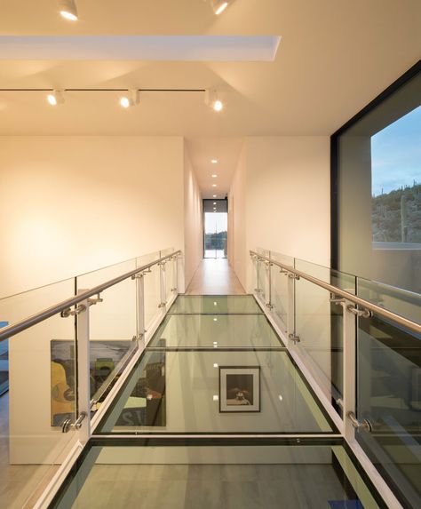 In this modern house, there's a glass bridge that crosses the art gallery and connects the living areas with the bedrooms. #GlassBridge #Architecture #GlassWalkway Modern Hillside House, House In Arizona, Glass Walkway, Modernist Furniture, Glass Bridge, Hillside House, Desert Homes, Interior Stairs, Glass Floor