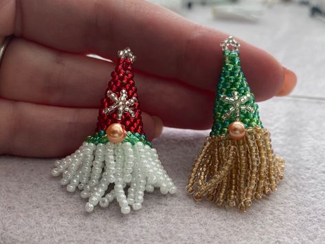 Two small green and red beaded gnomes held up by a hand Beaded Pinecone Tutorial, Christmas Crafts Beads, Beaded Christmas Crafts, Easy Beading Patterns Free, Gnome Earrings Diy, Beaded Gnome Earrings, Beaded Ornaments Diy Free Pattern, Teardrop Beaded Earrings, Beaded Christmas Earrings Diy