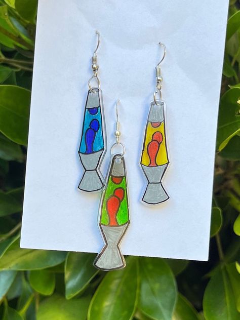 These super cute earrings are lava lamps made out of shrinky dinks. They come in 3 different color options. They are lightweight and perfect for any fun outfit! Fall Shrinky Dink Ideas, Lava Lamp Earrings, Shrink Plastic Ideas Diy, Christmas Shrinky Dink Ideas, Cute Shrinky Dink Ideas, Juniper Art, Shrink Earrings, Woodstock Theme, Shrinky Dink Ideas