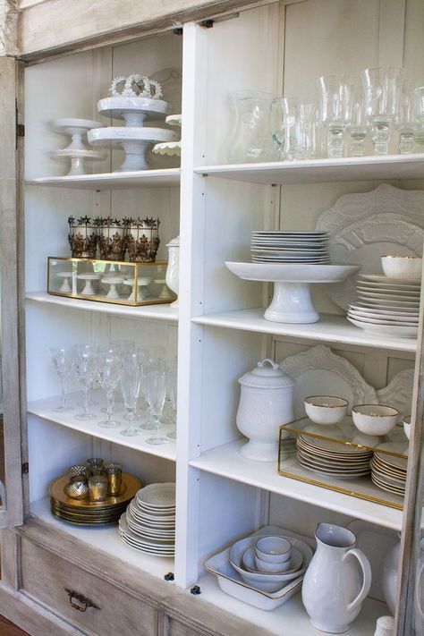 How to style your china cabinet. China Cabinet Essentials A set of white dishes {dinner plates, salad plates, bowls} Set of glassware {stemware & tumbler} Set of Silverware {gold and / or silver} Napkin Rings Chargers 3-5 Serving Platters Large Pitcher Cake Plates Votives & Candle Sticks White Napkins China Cabinet Set Up, How To Store Serving Platters, How To Style Buffet Cabinet, How To Display Glassware, How To Display Dishes In China Cabinet, How To Display China In Cabinet, China Cabinet Organization, China Cabinet Display Ideas, China Display Ideas