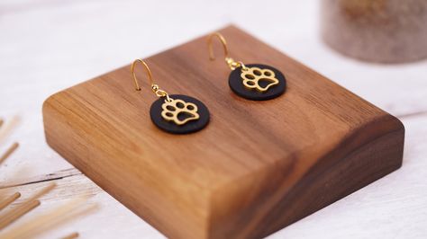 🐾 NEW Paw Print Earrings – Perfect for Animal Lovers! 🖤 Looking for a stylish way to show off your love for pets? Check out these gorgeous black circle dangle earrings with a gold paw print charm! 🐶🐱 Handmade from polymer clay, these earrings are not only lightweight and comfortable but also hypoallergenic, making them perfect for sensitive ears. Whether you're treating yourself or looking for the perfect gift for an animal lover, these earrings will make a unique addition to any jewellery ... Paw Print Earrings, Polymer Clay Jewellery, Paw Print Charm, Paw Print Design, Black Circle, Clay Jewellery, Lightweight Earrings, Pet Owner, Earring Hooks