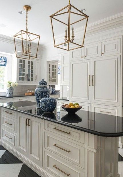 One kitchen trend that’s gaining momentum as we head into the new year is white cabinets with black countertops, commonly referred to as the ‘tuxedo kitchen.’ Not only is the contrast of white against black dramatic and alluring, it’s practical. Black countertops hide stains and smudges, while white cabinets are a timeless and functional choice for any kitchen design style. Cage Pendant Light Over Island, White Kitchen Floor, Cream Kitchen Cabinets, Antique White Kitchen Cabinets, Antique White Kitchen, Pendant Lantern, Chandelier Vintage, Black Countertops, Farmhouse Kitchen Island