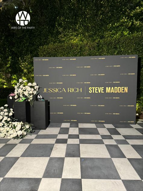 Guests were welcomed by a striking black and gold step and repeat, showcasing Jessica's favorite shoes on sleek black podiums, all accented with elegant white floral installations.  #wotp #thewotp #wifeoftheparty #partyplanner #eventplanning #thewotp #thewifeoftheparty #event #eventplanner #events #losangelesevents #wecelebratepeople #loriannserna #stevemadden #stevemaddenxjessicarich #shoes #collaboration #thependrywesthollywood Luxury Corporate Event Decor, Corporate Backdrop Design Events, Corporate Event Photo Booth, Company Event Decoration, Event Set Up Ideas, Step And Repeat Ideas, Conference Decorations Events, Corporate Event Backdrop, Event Mood Board