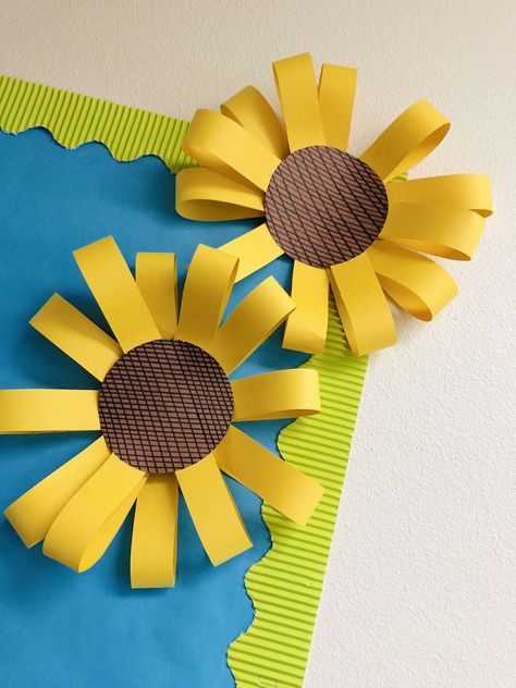 Love these little details!   Supplies needed: construction paper, scissors, ruler, permanent marker, stapler, hot glue.     •Create petals by using construction paper and ruler.  •Cut, bend, and staple together to make flower.   •Use ruler to make lines for the middle of your sunflower  •Glue middle to your flower.   •Attach to board/door or wherever your choose! Construction Paper Classroom Decor, Flowers For Bulletin Board Diy, Fall Flower Bulletin Board, Construction Paper Decor, Construction Paper Sunflower, Sunflower Door Decor Classroom, Fall Construction Paper Crafts, Sunflower Bulletin Board Ideas, Chart Paper Decoration Ideas