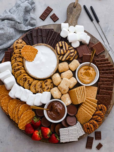 Just in time for summer barbecues and camping trips, this s'mores charcuterie board is here to sweeten things up! It features a mix of different types of chocolate, crackers, marshmallows, and spreads so everyone in your family can create their own perfect sweet treat. S'more Platter, Halloween S’more Charcuterie Board, Smores Grazing Board, Camp Theme Charcuterie Board, S’more’s Charcuterie Board, Bonfire Charcuterie Board, S’mores Charcuterie Boards, S'mores Charcuterie Board Ideas, S’more Fun Birthday