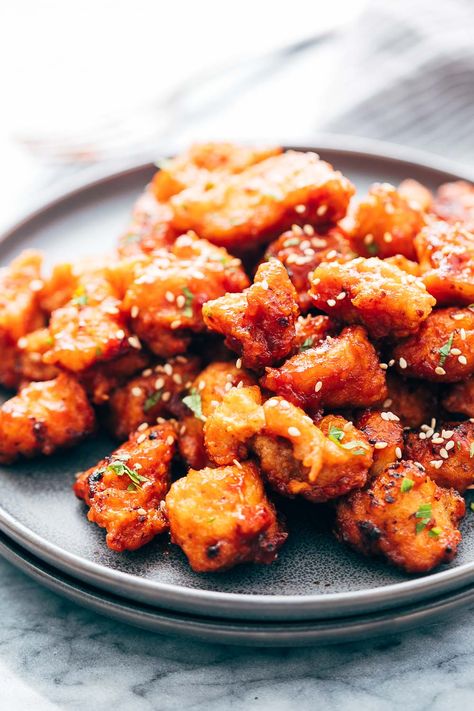 Korean Style Popcorn Chicken. Not complicated! Chicken thighs get tossed with garlic and salt, coated in corn flour and fried. A mix of ketchup (I'd use good quality!), soy sauce, fresh ginger, rice vinegar, and hot sauce get cooked together and then tossed with the fried chicken pieces. Umm, yum! Korean Popcorn Chicken Recipe, Fried Popcorn Chicken, Chicken Pops, Baked Popcorn Chicken, Chicken Appetizer, Bang Bang Shrimp Recipe, Ginger Rice, Chicken Pop, Popcorn Chicken Recipe