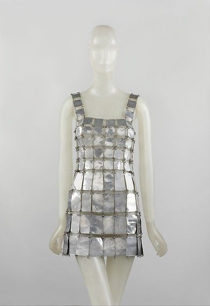 Paco Rabanne: This dress is made of metallic by Paco Rabanne in 1967. He used a lot of plastic, metal, and paper to create his looks. He was also a costume designer for Barbarella. A lot of his garments resemble NASA space suits which was a reflection of the 1960s space exploration. Paco Rabanne Dress, Space Age Fashion, Metal Dress, Space Fashion, Mary Quant, Fashion 1960s, Costume Institute, Futuristic Fashion, Art Dress