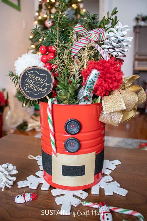 Make a statement with this sweet DIY Santa centerpiece using an upcycled coffee tin and plenty of holiday embellishments. Tin Can Santa Claus, Coffee Tins Upcycle, Coffee Can Christmas Crafts, Can Christmas Crafts, Tin Can Christmas Crafts, Christmas Tin Can Crafts Ideas, Unique Christmas Crafts, Tin Can Christmas, Santa Centerpiece