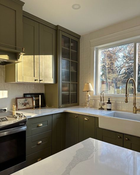 These olive green cabinets have a natural and earthy feel while still maintaining a sense of modernity. Additionally, incorporating metallic accents can further elevate the overall aesthetic, creating a harmonious look. Olive green kitchen cabinet from @natalieapaquin Khaki Green Kitchen Cabinets, Green Kitchen Walls With Wood Cabinets, Khaki Green Kitchen, Dark Olive Cabinets, Green Accent Kitchen, Cotswolds Kitchen, Green And Grey Kitchen, Olive Kitchen Cabinets, Green And Brown Kitchen