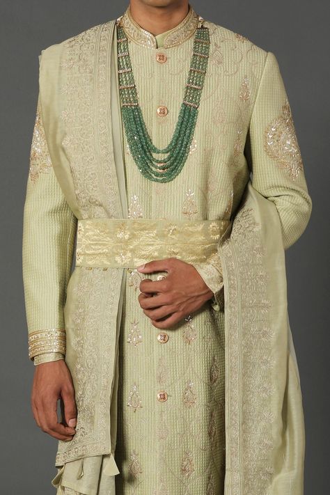 Mint sherwani with quilted base, sequin mughal jaal and aari work embroidery. Comes with a matching kurta, churidar, embellished belt and a tasselled shawl. Component: 5 Pattern: Woven, Embroidered Type Of Work: Quilted, Mughal Jaal, Aari work Neckline: Mandarin collar Sleeve Type: Full Fabric: Chanderi Handloom, 50% Silk, 50% Cotton, Lining: Shantoon Color: Green Other Details:  Fabric tasselled dupatta Tasselled belt Attached lining Note: Outfit worn by the female model and outfits worn by mal Mughal Fashion, Mughal Jaal, Aari Work Embroidery, Tassel Belt, Embellished Belt, Studio Green, Aari Work, Female Model, Sherwani