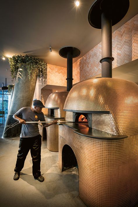 Two gigantic imported Stefano Ferrara pizza ovens, widely considered the Rolls-Royce of pizza ovens, are open to the restaurant. They have been clad ingold mosaics to add a theatrical aspectto the experience of dining at Saint. Pizza Oven Bar, Pizza Oven Restaurant Design, Wood Fired Pizza Oven Restaurant, Pizzeria Kitchen Design, Pizza Oven Mosaic, Pizza Restaurant Ideas, Wood Fired Pizza Restaurant, Pizza Shop Interior, Pizza Restaurant Design