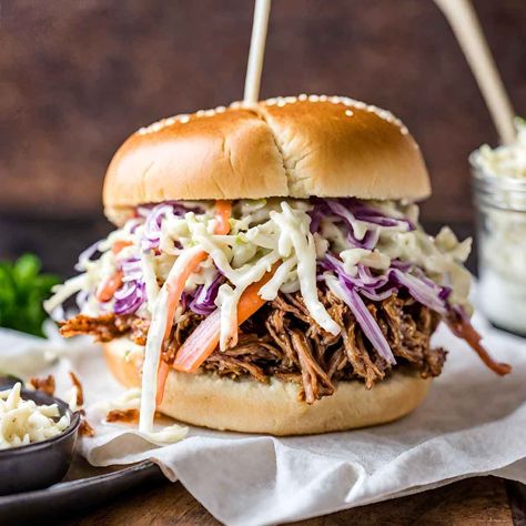 Juicy, tender pork pickled and slow cooked to perfection, topped with a creamy coleslaw and served on a toasted bun. An oldie but most definitely a goodie. Bbq Sandwiches Crockpot Pulled Pork, Coleslaw Topping For Pulled Pork, Bbq Coleslaw Recipe Pulled Pork, Pulled Pork Sandwiches With Coleslaw, Best Crockpot Pulled Pork Bbq, Best Pulled Pork Sandwiches, Pulled Pork Sliders With Slaw, Toppings For Pulled Pork Sandwiches, Bbq Pork Sandwiches Crockpot