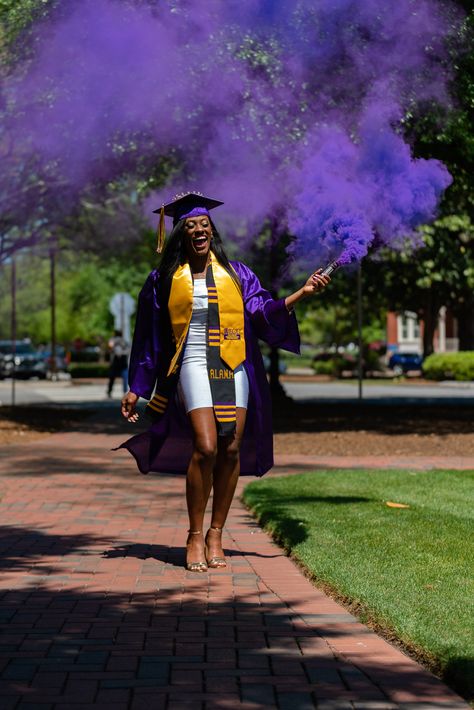 Our first time using smoke bombs... Ever! Believe it or not, it took us only one shot to get it right.    #essence #trueessencephotography #photography #photography #sonyshooter #blackisbeautiful #black #gold #purple #ecu #eastcarolina #fountain #water #patience #smile #beautiful #gown #capandgown #cap #tassel #outside #beforecovid #dress #smoke #smokebomb Purple Graduation Outfit, Purple Senior Pictures, Purple Cap And Gown Graduation Outfit, Ecu Graduation Pictures, Night Graduation Photoshoot, Lsu Graduation Pictures, Purple Graduation Gown, Outdoor Graduation Photoshoot Ideas, Graduation Poses Cap And Gown