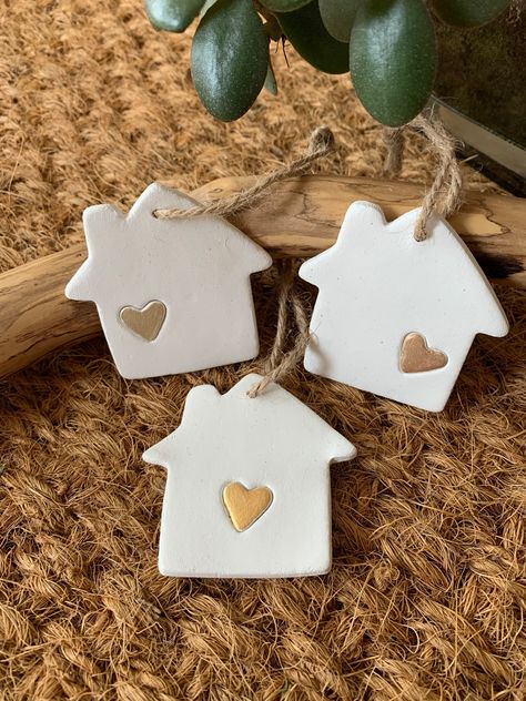 Set of 3 houses with painted hearts in different shade of gold.  The houses can be used as tree decorations and gift embellishment.  They are a lovely touch to add to a small gift when you are invited. This is for all those that make a house, a home and welcome you in the advent time and beyond. Handmade using Air Drying Clay and embossed by hand, so may differ slightly from the pictures. When the clay is dry, it is lightly sanded and attached with a natural twine jute and  painted with water ba Salt Dough Ornament Decorating Ideas, Air Dry Clay Ideas Christmas Decorations, Diy Christmas Clay Ornaments, Diy Christmas Ornaments Clay, Christmas Decor Clay, Christmas Decorations Clay, Diy Clay Ornaments Christmas, Christmas Air Dry Clay Ideas, Air Dry Clay Ideas Christmas