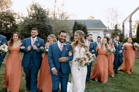 Navy groomsmen suits and terracotta bridesmaid dresses group bridal party photo Terracotta Groomsmen Attire, Copper And Navy Wedding, Navy Blue And Terracotta Wedding, Navy Bridal Parties, Navy Groomsmen Suits, Navy Groomsmen, Burnt Orange Bridesmaid Dresses, Navy Suit Wedding, Bridal Parties Colors