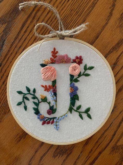 Custom made, hand embroidered floral letter. Made with 100% cotton fabric as well as DMC 100% cotton thread. The hoop used is 5 inches in diameter, natural wood. Completed with paper backing to protect stitching.  Can create any letter. The colour schemes to choose from will represent the majority of the colours used for the flowers with some variation used for smaller flowers, stems and leaves.  This will make a perfect gift for anyone. Lovely for kids rooms and nurseries, birthday and shower g Flower Letters Embroidery, F Embroidery Letter, Embroidered Initials Hand Embroidery, Hand Embroidered Initials, A Letter Embroidery Design, Embroider Gift Ideas, Embroidered Letters Floral, K Embroidery Letter, J Embroidery Letter