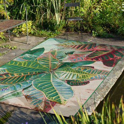 Ground your living room or porch in coastal style with this tropical area rug with billowing leaves in green and pink. Made from polypropylene, it's fade and stain-resistant, making it a great choice for areas with lots of foot traffic. The low pile height ensures easy maintenance, while the intricate design adds a touch of visual interest to your decor. When it's time for a refresh, simply hose it down and lay it flat to dry. We recommend pairing it with a rug pad to add extra cushion, as well Tropical Area Rugs, Tile Stairs, Flea Market Flip, Patio Rugs, Beachcrest Home, Outdoor Area Rug, Indoor Outdoor Area Rugs, Coastal Style, Floral Rug