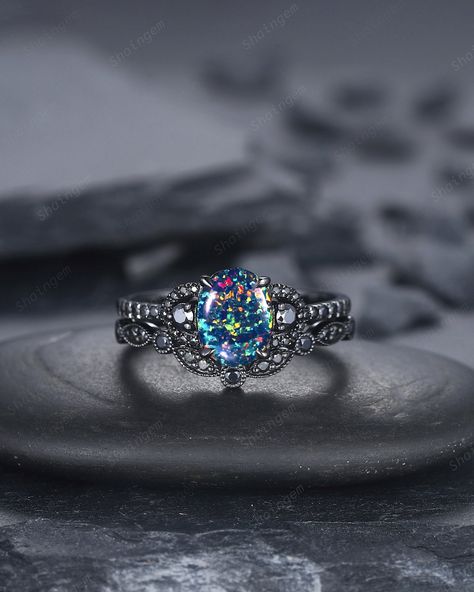 Rhodium black engagement ring like no other. This AMAZING piece of fine jewelry is the perfect expression of your eternal love. Its BLACK colors bring out the beauty of this ring. More black gold rings ,please click here: https://www.etsy.com/shop/ShainGem?section_id=36322715 ★Description Main ring: *Center stone: 6x8mm Oval Shape Lab Black Opal *Accent stone: 0.23 Carat black moissanite  * Material: The underneath metal is in Silver/ 10K/14K/18K white gold, coated with black rhodium *Band Width(Bottom): 1.6mm Wedding band: *Accent stone: 0.15 Carat Black Moissanite  * Material: The underneath metal is in Silver/ 10K/14K/18K white gold, coated with black rhodium *Band Width(Bottom): 1.5mm Rhodium black engagement ring like no other. This AMAZING piece of fine jewelry is the perfect express Black Alexandrite Ring, Maleficent Engagement Ring, Vintage Alexandrite Engagement Rings, Dark Engagement Ring, Witchy Engagement Ring, Black Engagement Ring Set, Purple Engagement Ring, Black Gold Engagement Ring, Witchy Ring