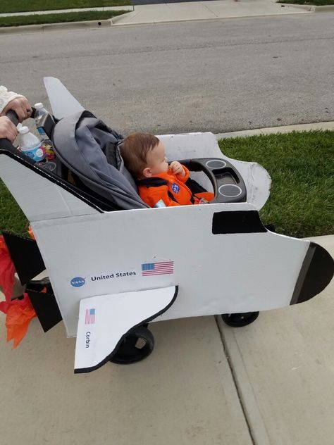 DIY space shuttle stroller Halloween costume-astronaut Astronaut Halloween Family Costume, Rocket Stroller Costume, Spaceship Stroller Costume, Stroller Rocket Ship, Astronaut Toddler Costume, Stroller Rocket Ship Costume, Costumes With Strollers, Halloween Stroller Costumes, Halloween Stroller Ideas