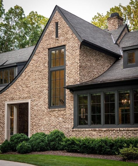 An exposed brick wall match with any home style. Like the picture above, by using exposed brick walls, it gives the exterior of the house look aesthetic. Combine it with black window trim for a more cohesive look. Exposed Brick Wall from @castlehomes #brick #brickhomeexterior #classichomeexterior #homeexterior #homeexteriormaterials #timelesshomeexterior Modern Red Brick Fireplace, Exterior House Colors With Brick Red, Black Windows Brick House, Copper Porch Roof, Dark Exterior House Colors With Brick, Light Brown Brick House Exterior, Dark Gray Brick House Exterior, Brick And Stone Home Exterior, Exterior With Red Brick