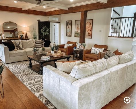 These two gray couches seated opposite each other help balance out an awkward layout in this living room. The couches are paired with a dark-stained wood coffee table. Brown leather accent chairs are arranged next to the couches. Couches Facing Each Other Layout, Rooms With Corner Fireplaces, Two Couches Facing Each Other, Brown Leather Accent Chairs, Two Sofas Facing Each Other, Rectangular Living Room Layout, Beige Sectional Couch, Gray Couches, Awkward Living Room