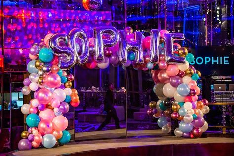 This glamorous Bat Mitzvah at the Rainbow Room in New York City captivated guests the moment they arrived. The purple uplighting highlighted the chic lounge furniture and brilliant metallic balloons displayed all throughout this unforgettable celebration. From the entertainers wearing a festive balloon headdress to the remarkable balloon arch with the guest of honor’s name, Balloon Design Studio created outstanding balloon elements to celebrate Sophies Bat Mitzvah! Purple Uplighting, Room In New York, Mitzvah Decor, Pretty Balloons, Balloon Display, Chic Lounge, Metallic Balloons, Rainbow Room, Taste The Rainbow