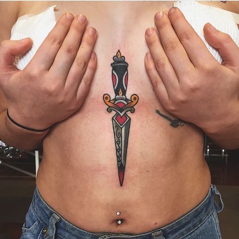 Traditional dagger tattoo inked on the sternum and belly Sternum Traditional Tattoo, Traditional Tattoo Sternum, Sternum Tattoo Dagger, Dagger In Heart Tattoo, Dagger Sternum Tattoo Women, Sternum Tattoo American Traditional, Dagger Tattoo Sternum, Trad Dagger Tattoo, Underboob Tattoo Traditional