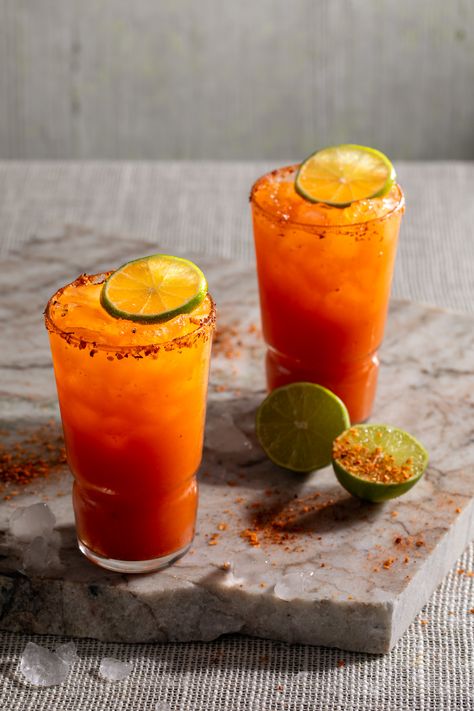 Two Michelada cocktails orange red in color sit in tall glasses, garnished with lime and Tajín. Michelada recipe Michelada Recipe, Batch Cocktail Recipe, Grilled Watermelon, Chili Lime Seasoning, Drink Stand, Mexican Beer, Mexican Drinks, Spicy Seasoning, Tomato Relish