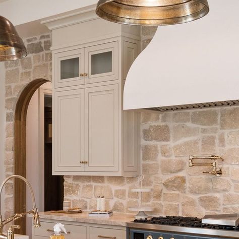 Davies Design Build on Instagram: "The kitchen in our 2023 @uvparade home was a fan favorite! We loved taking our clients vision and bringing it to life. Here are the details! -The stone we used is from @beehivebrickandstone and we used the Bonneville stone with white grout. -The cabinet color is SW Accessible Beige. #kitchendesign #cabinetdesign #designbuild #sketchup #utahbuilder #utahcustomhomebuilder #constructbuild #buildersofig #luxedesign #beautifulhome #interiorarchitecture #luxehome #dreamhome #utah #designbuild #construction #constructionlife #stone #realestate #design #interiordesign #finishcarpentry #lightingdesign #kitchenbacksplash #kitcheninspiration #kitchen" Kitchen Stone Wall Ideas, Stonework In Kitchen, Stone Range Hood Kitchen, Tan Stone Backsplash Kitchen, Cottage Kitchen Stone Wall, Stone Backsplash Behind Stove, Stone Wall Backsplash, White Kitchen Stone Backsplash, Natural Kitchen Backsplash