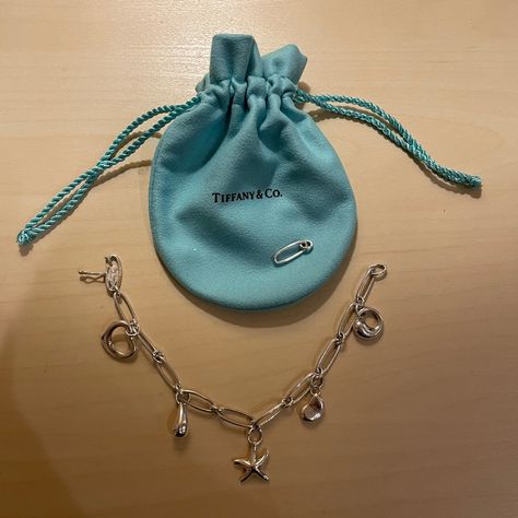 Tiffany & Co Elsa Peretti Charm Bracelet Retailed For $950 Plus Tax Includes Extra Link. Currently Fits 7 Inch Wrist. Includes Brand New Tiffany Blue Pouch. It Is In Excellent Condition. Charm Bracelet In Sterling Silver, With Bean Design, Eternal Circle, Starfish, Teardrop And Open Heart. Tiffany Charm Bracelet, Tiffany And Co Bracelet, Tiffany And Co Jewelry, Elsa Peretti, Tiffany And Co, Open Heart, Tiffany Blue, Tiffany & Co., Womens Jewelry Bracelets