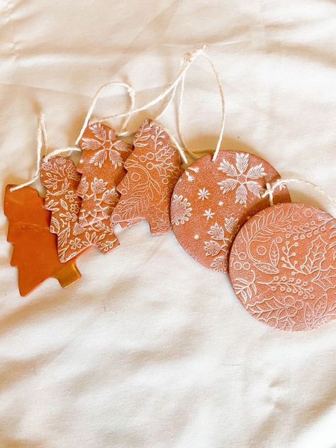 "Aged Terra Cotta Hand Stamped Christmas Tree and Circle Ornaments. Christmas trees are about 3.25 inches tall and circles are 3 inches in diameter. These ornaments are polymer clay which has been hand stamped, textured, and painted to create a beautiful aged terra cotta finish. Ornaments are stamped on the back with \"2023\". These ornaments are lightweight and will not weigh down your branches. Choose between plain, holly, floral, and snowflake patterns. Create a whole set! Ornaments are made Terra Cotta Christmas Tree, Terra Cotta Clay Crafts, Terracotta Christmas Ornaments, Terracotta Christmas Tree, Terracotta Christmas Decor, Terracotta Clay Crafts, Painted Clay Ornaments, Terra Cotta Ornaments, Terra Cotta Decor