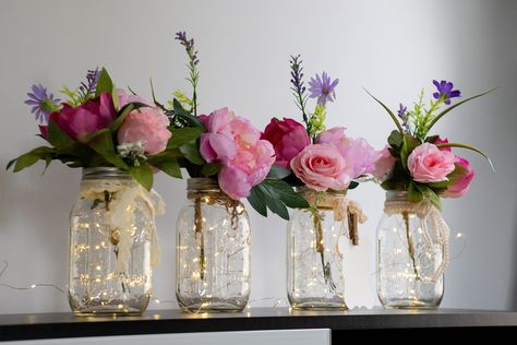 "This is a hand made elegant set of four Fairy Light Mason Jar Centerpieces are perfect for your wedding or event or adding a touch of farmhouse charm to your home decor. You can choose from two sizes: pint or quart, or a set of both. You can also select from six different flower bouquet color variants that match any theme or occasion. Each centerpiece jar comes complete with warm white LED fairy lights, which add a subtle glow to any setting, one silk flower bouquet, and a complementing ribbon, Light Wedding Decor, Mason Jar Light, Lighted Centerpieces, Lights Wedding Decor, Event Centerpiece, Flowers In Jars, Silk Flower Bouquets, Light Wedding, Mason Jar Centerpieces