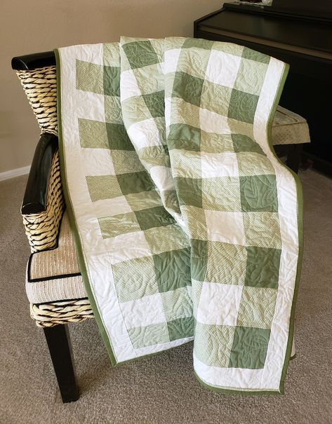 Gingham is one of the most familiar patterns of the ages, but did you ever really study how it's constructed? A dark square, a light square, and two diagonally-printed mid-range squares. The greens in this quilt are soothing, and the reverse is a quilt all on its own with a center panel of green growing things bordered in a white-on-white fabric. It is quilted overall with a gorgeous leaf pattern. Simple Square Block Quilts, Shades Of Green Quilt, Gingham Patchwork Quilt, Easy Quilts For Beginners Simple Free Pattern, Checker Quilt Pattern, Quilt Embroidery Designs, Green And Blue Quilts, Dark Quilt Patterns, Sage Green Quilt Ideas