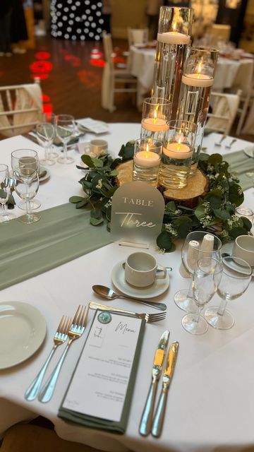 G&L Elegant Occasions on Instagram: "Another lovely night at @bartonhallhotelandspa wedding fair ✨ Sage green and cylinder vases with floating candles is always one table everybody loves! 😍 • • • • • #wedding #weddingday #engaged #engagement #weddingdecor #weddingsnorthamptonshire #weddingseastmidlands #weddingsleicestershire #eventdecor #bridetobe #groomtobe #weddingstyle #venuestyling #venuestylist #wedding2024 #bride2024 #bride2025 #weddingday #venuestyling #venuestylistnorthamptonshire #bartonhall #bartonhallwedding #sagegreen #sagegreenwedding" Sage Green Wedding Reception Table, Plant Table Setting, Sage Green Wedding Table Linens, Rustic Wedding Sage Green, Sage Reception Decor, Wedding Tables No Chargers, Wedding Table Centerpieces Wood Slices, Table Set Up Wedding Receptions, Sage Green And Gold Wedding Theme Centerpieces