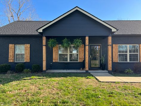 Painted black house, diy shutters and posts! Black Brick Ranch House Exterior, Black Brick Ranch House, Black Trailer Home Exterior, Black Painted Brick Exterior, Black Ranch House Exterior, Black Mobile Home Exterior, Ranch House Exterior Colors, Ranch Style House Exterior, Brick Makeover