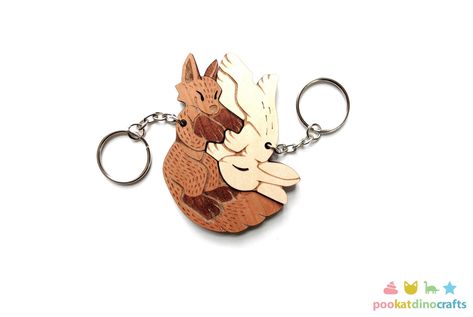 My original design fox and rabbit keychain pair are engraved and cut from beautiful cherry and maple wood. They interlock and fit together perfectly. The fox charm is 3" inches long and the rabbit is 2 3/4" inches long. They are laser-cut in-house from cherry/maple plywood that is approximately 3/16" thick. This listing is for the set of two matching keychains. They are both attached to your choice of silver, gold, antique, or gunmetal color keychains. *You can add customization to the back of y Rabbit Couple, Couple Keychains, Fox Charm, Rabbit Keychain, Paw Art, Mother Dearest, Fox And Rabbit, Laser Engraved Ideas, Couples Keychains